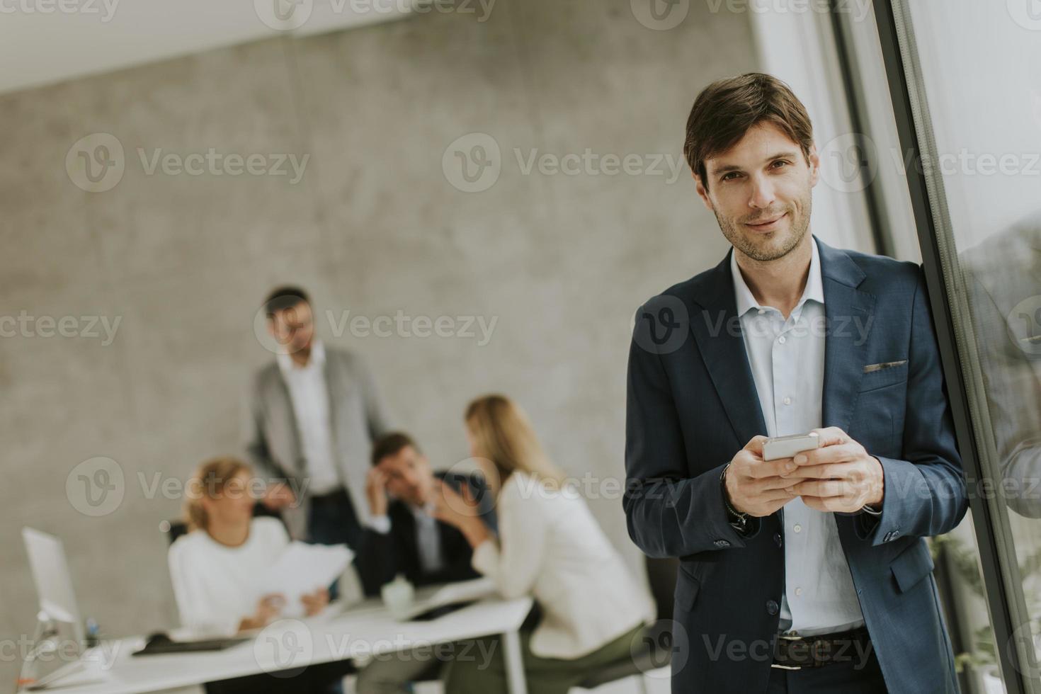 homme envoyant des SMS avec l'équipe en arrière-plan photo