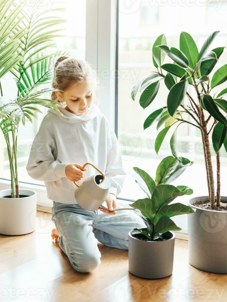 peu fille arrosage plantes d'intérieur dans sa maison 24024449 Photo de  stock chez Vecteezy