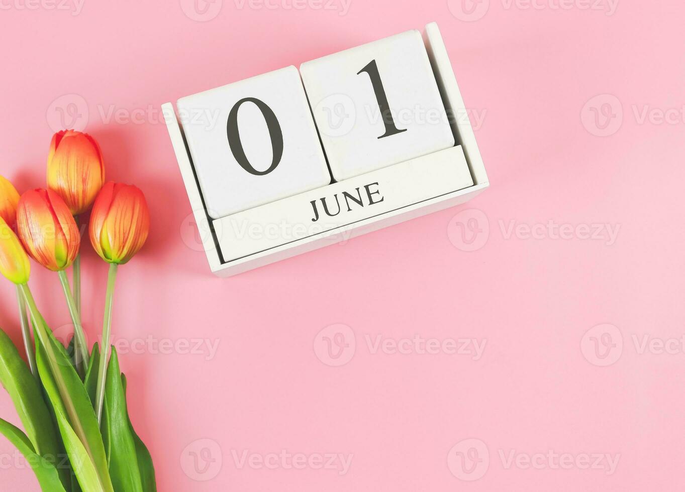 plat allonger de en bois calendrier avec Date juin 01 sur rose Contexte avec Orange et Jaune tulipes, copie espace. photo