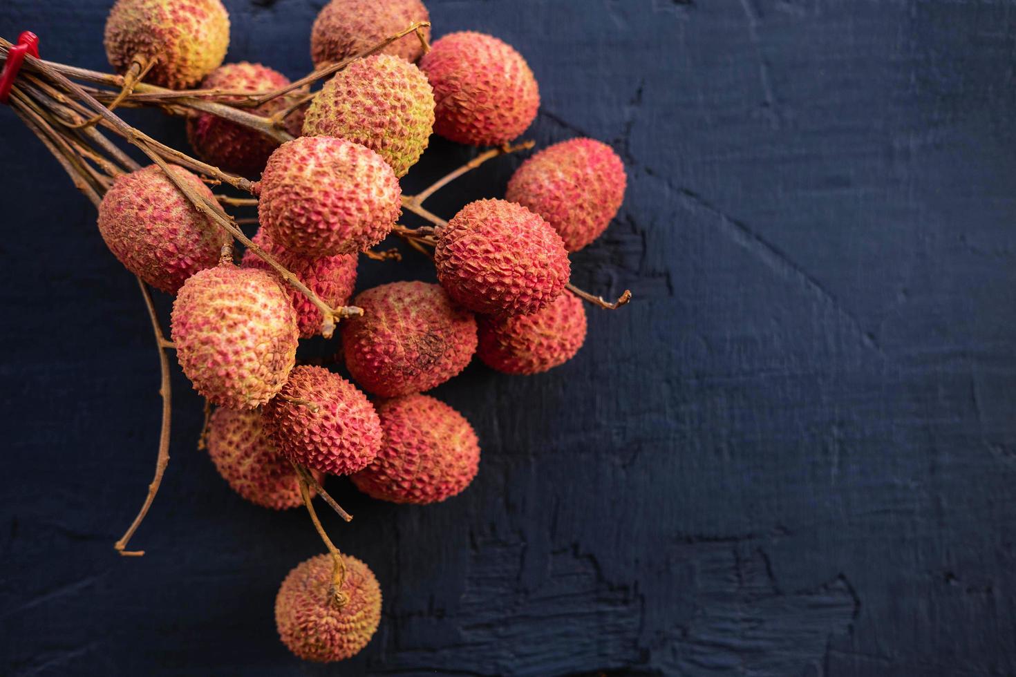 fruits de litchi frais sur un fond en bois noir. photo