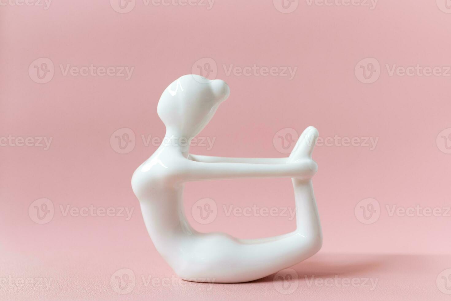 céramique yoga figurine de femme Faire yoga pose, dhanurasana arc pose sur rose Contexte photo