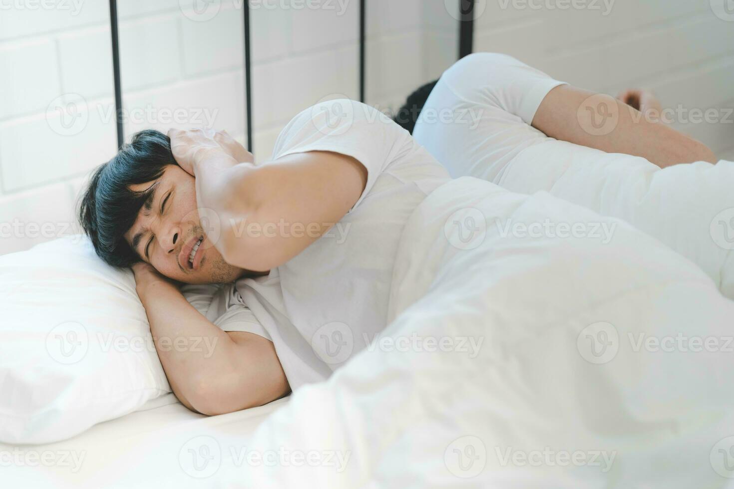 asiatique lgbt gay couple ayant problèmes dans lit. une homme couvertures le sien oreilles avec le sien mains de le du son de ronflement. photo
