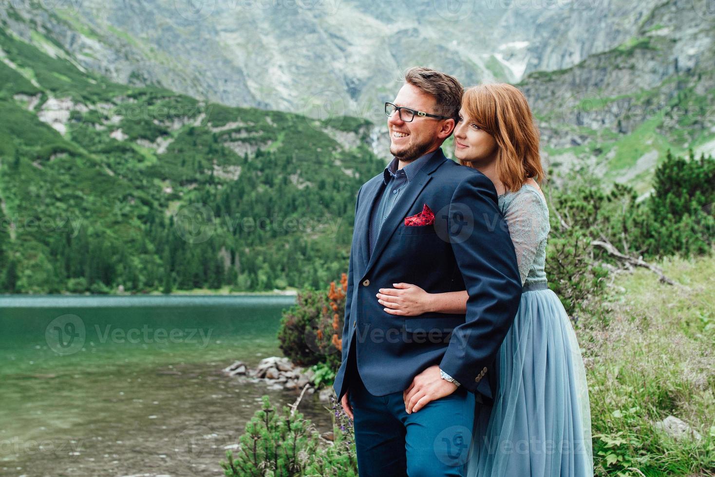 jeune couple en promenade près du lac entouré par les montagnes photo