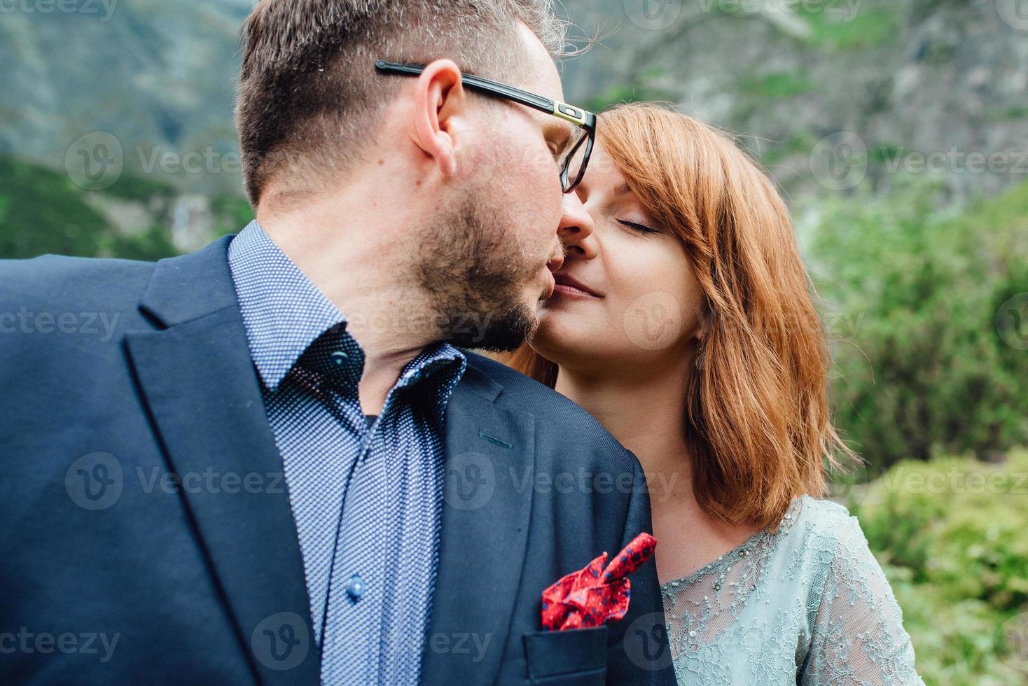 jeune couple en promenade près du lac entouré par les montagnes photo