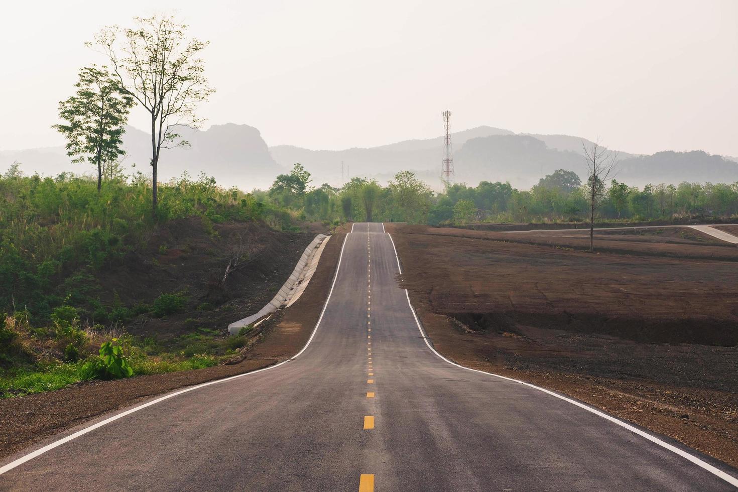 une longue route droite menant vers une montagne photo