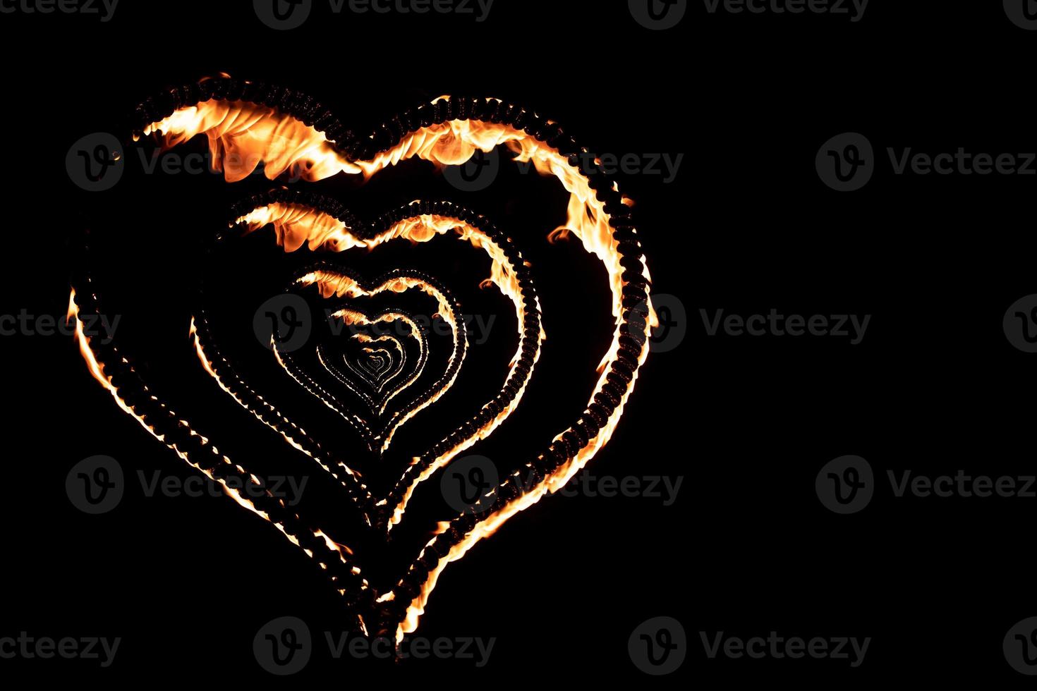 coeur brûlant avec des flammes isolé sur fond sombre photo