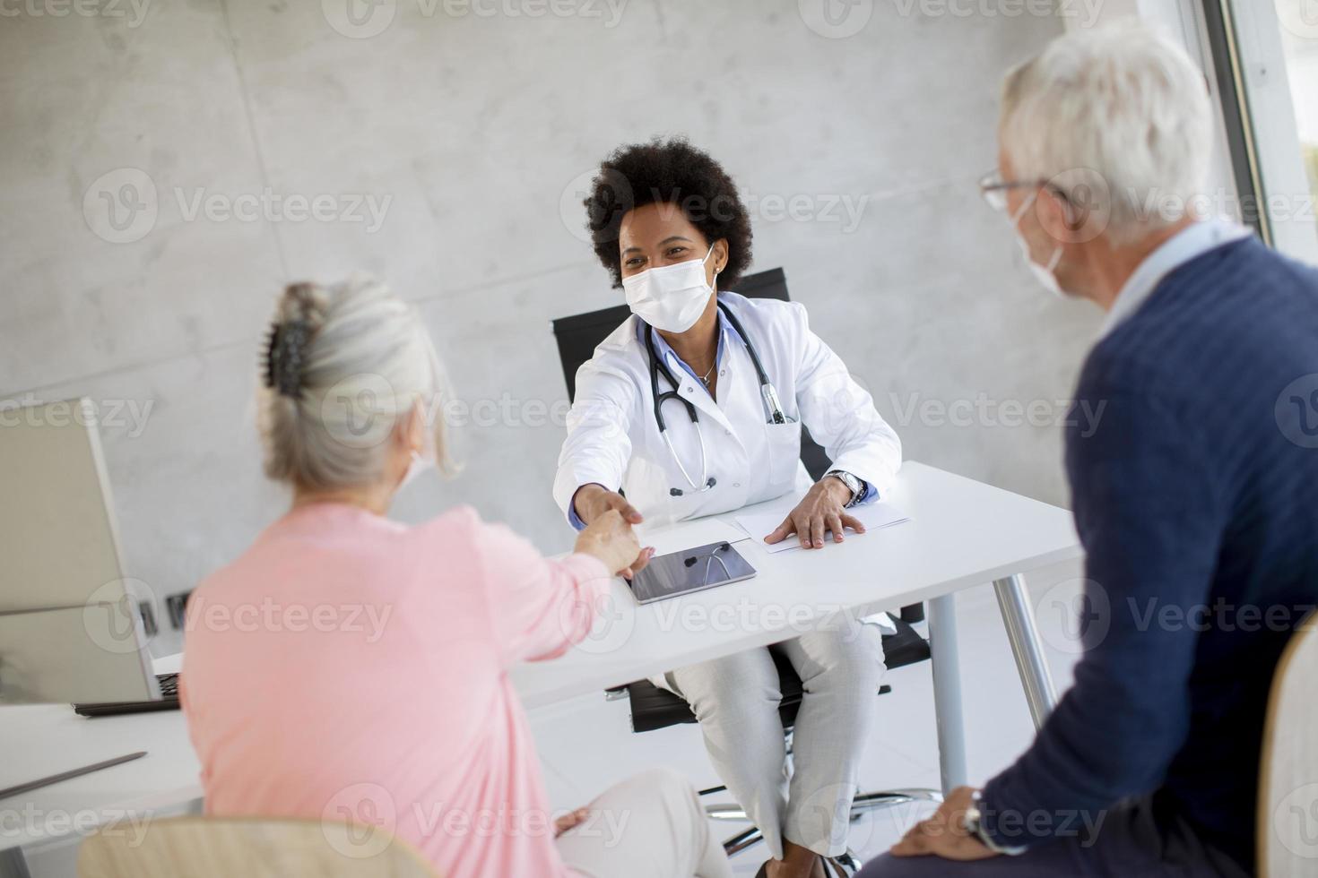 médecin donnant des nouvelles à un couple d'âge mûr masqué photo