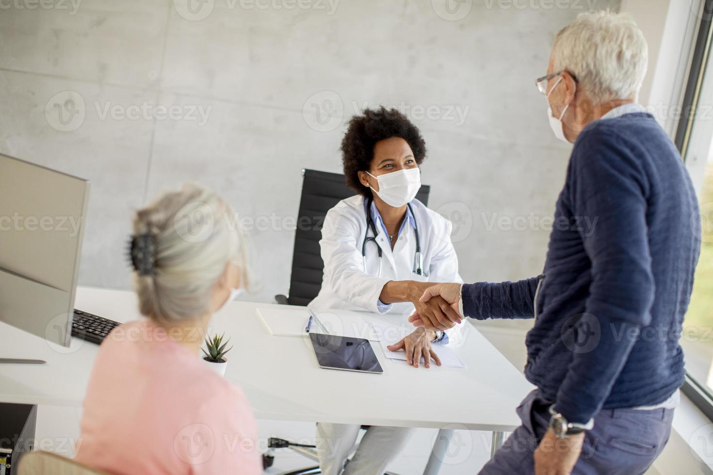 homme mûr masqué, serrant la main du médecin photo