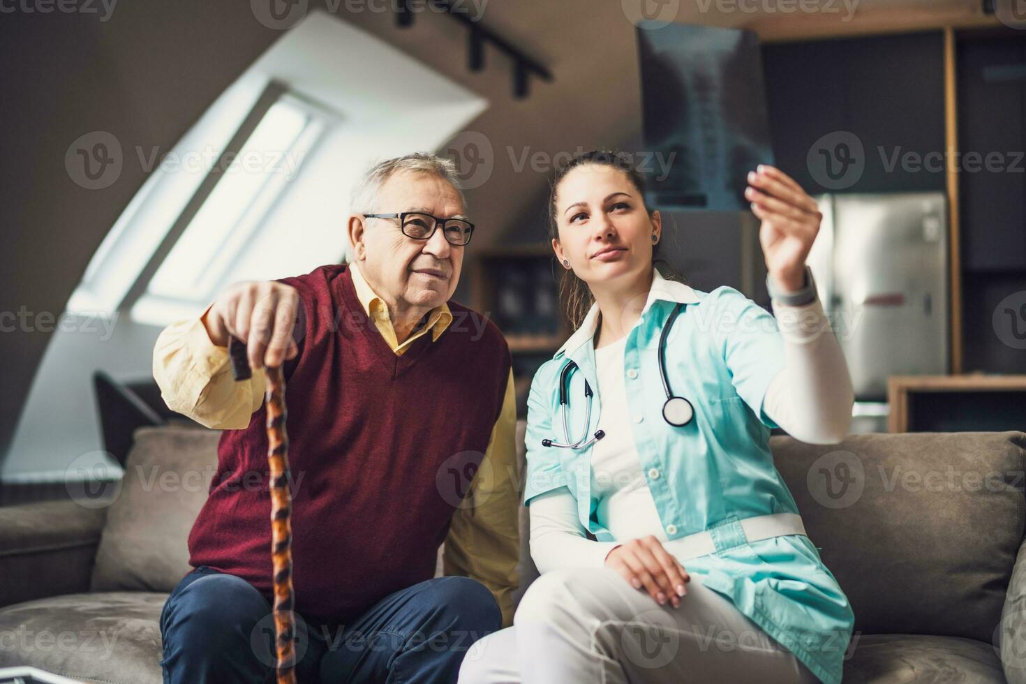 Accueil médecin est examiner radiographie image avec vieux homme à le sien maison. professionnel santé soutien pour personnes âgées personnes. photo