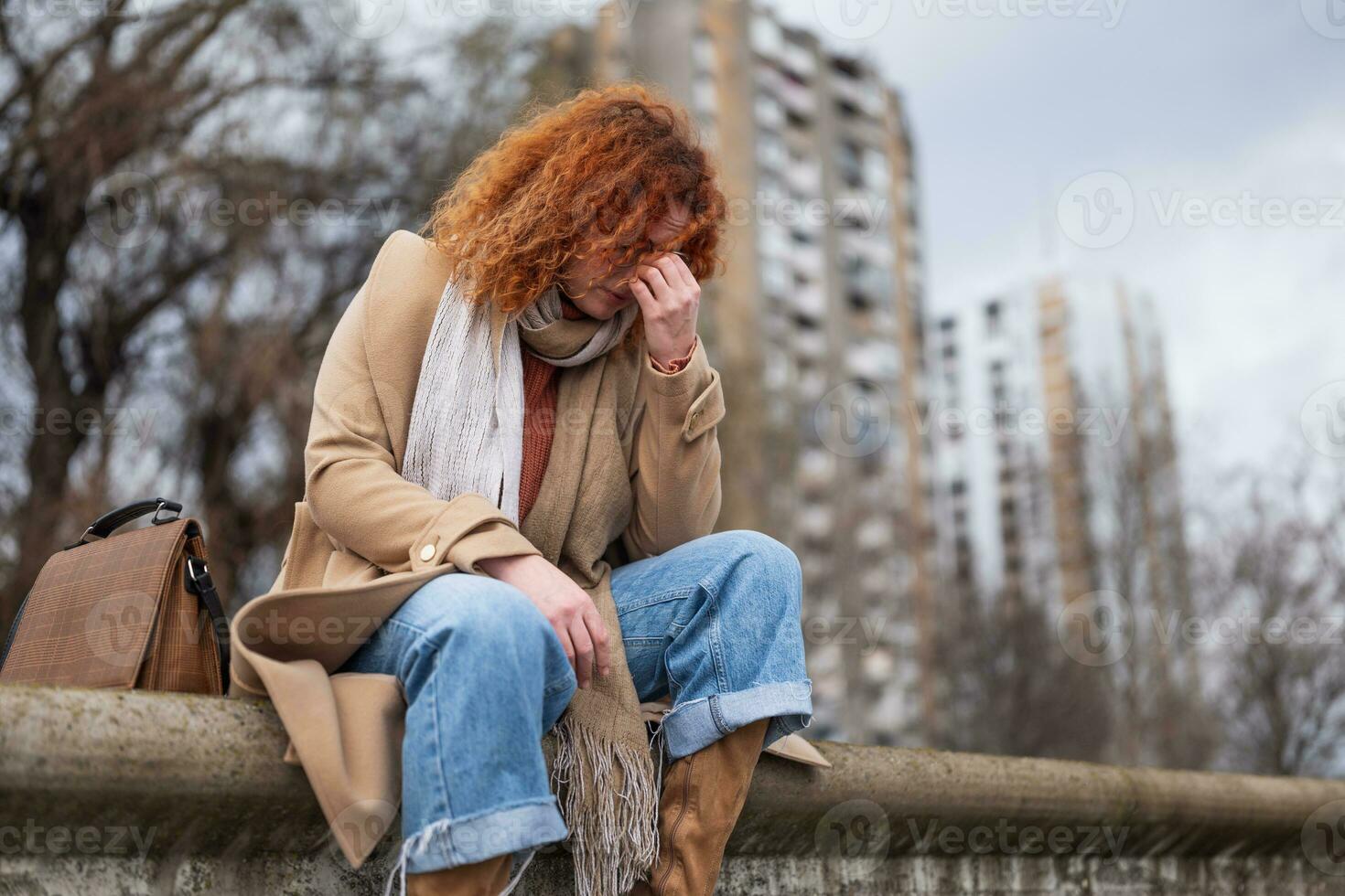 Naturel portrait de une caucasien gingembre femme avec taches de rousseur et frisé cheveux. elle est déprimé et fatigué. photo