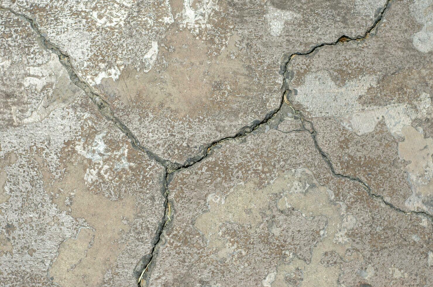 des fissures dans le surface de une route ou bâtiment mur photo