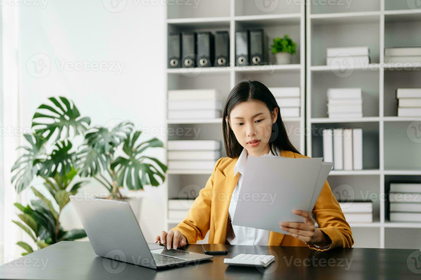 asiatique femme d'affaires travail dans le moderne Bureau avec travail bloc-notes, tablette et portable les documents photo