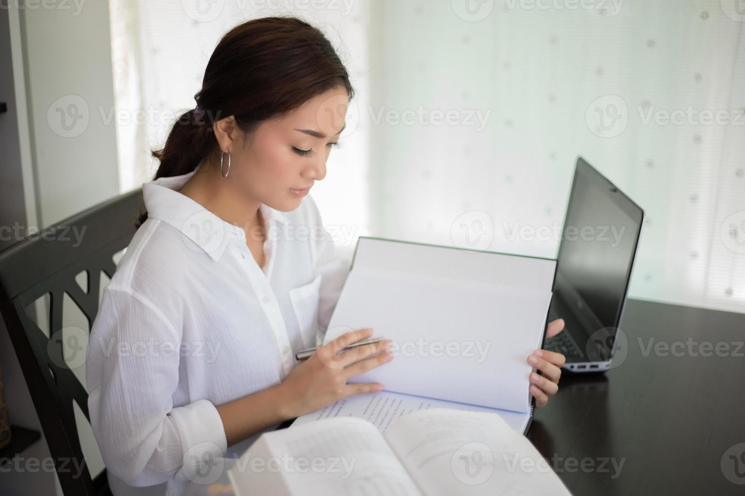 femme lisant et étudiant au bureau photo