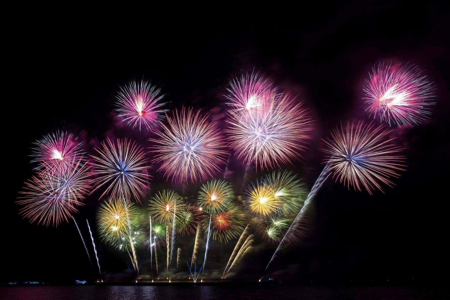 Beau feu d'artifice coloré festif sur la plage de la mer incroyable fête de feux d'artifice de vacances ou tout événement de célébration dans le ciel sombre photo