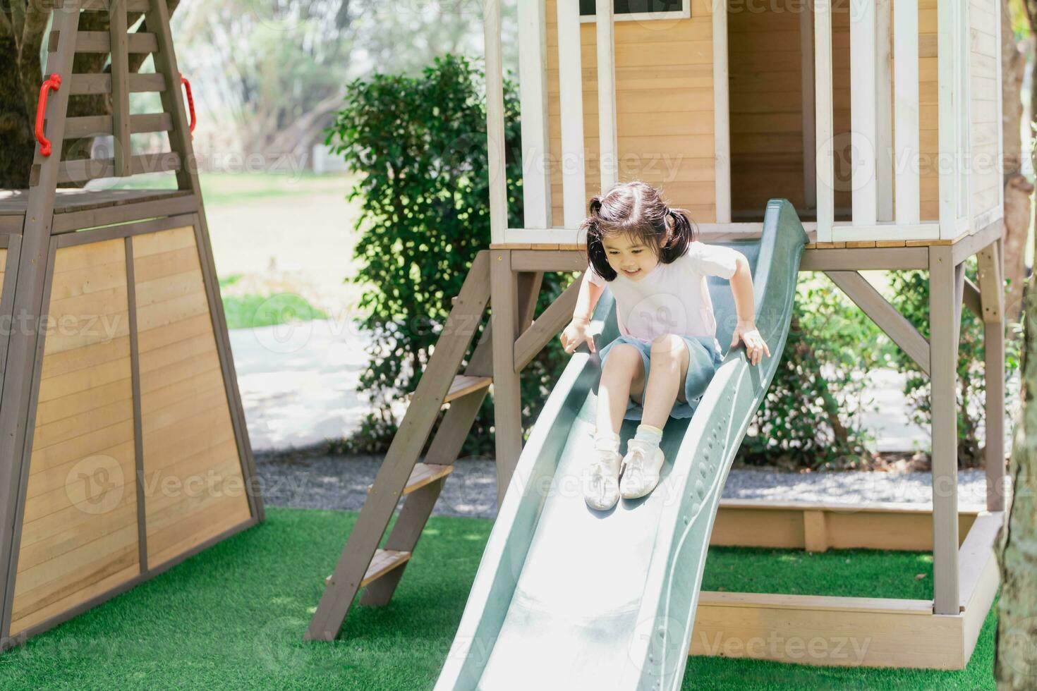 jolie fille asiatique sourire jouer sur la cour ou l'aire de jeux de l'école ou de la maternelle. activité estivale saine pour les enfants. petite fille asiatique grimpant à l'extérieur sur l'aire de jeux. enfant jouant sur une aire de jeux extérieure. photo