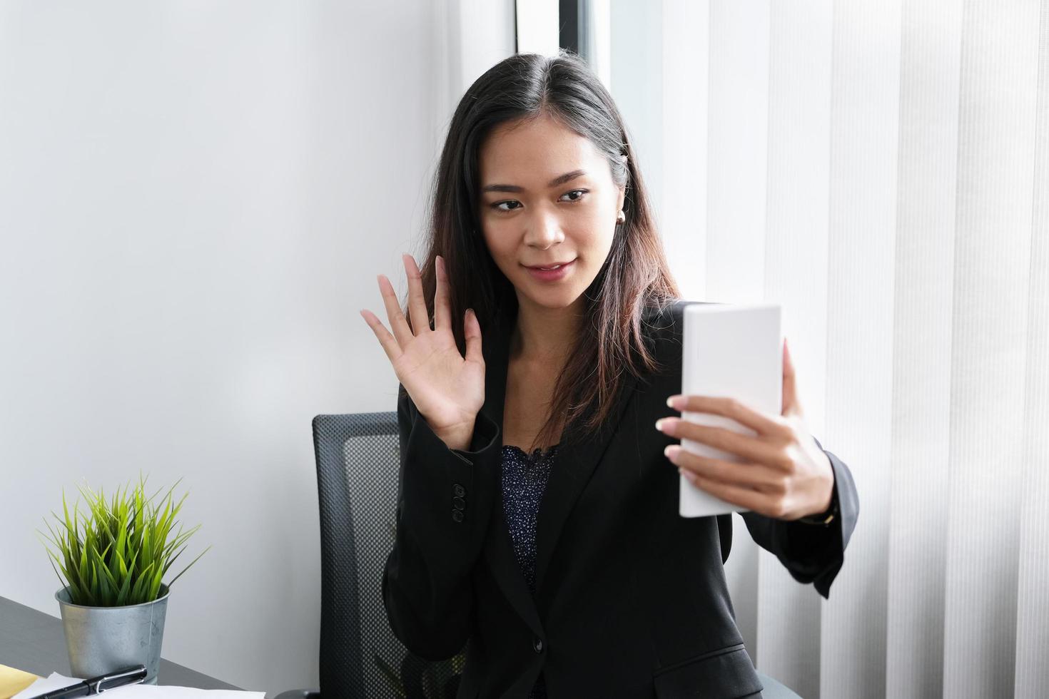 la jeune femme d'affaires est une conférence avec des personnes qui travaillent avec utiliser un smartphone photo