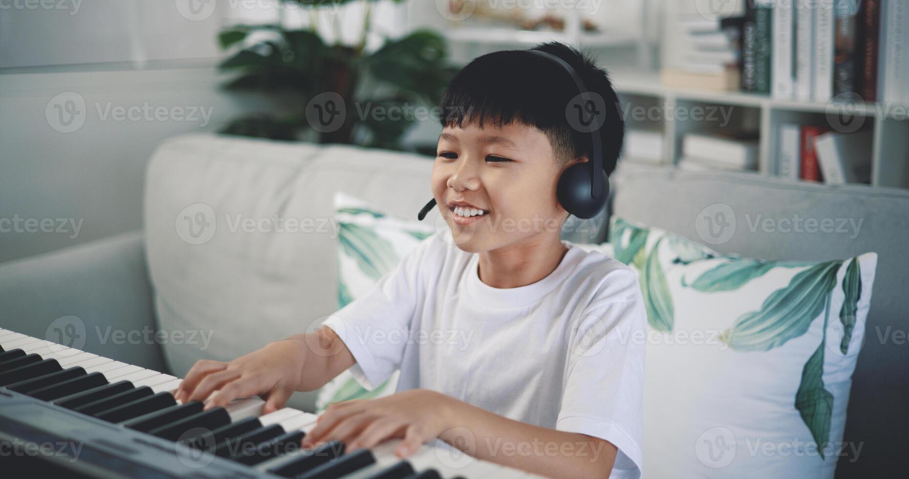 mignonne garçon prendre plaisir à apprentissage en jouant piano à Accueil photo