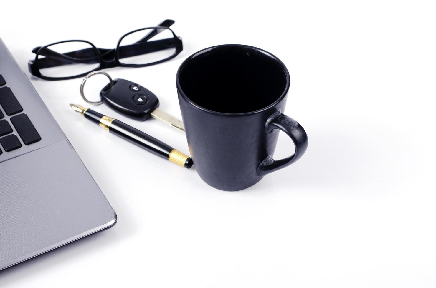 Tasse à café avec clé de voiture et stylo plume et lunettes sur fond blanc photo