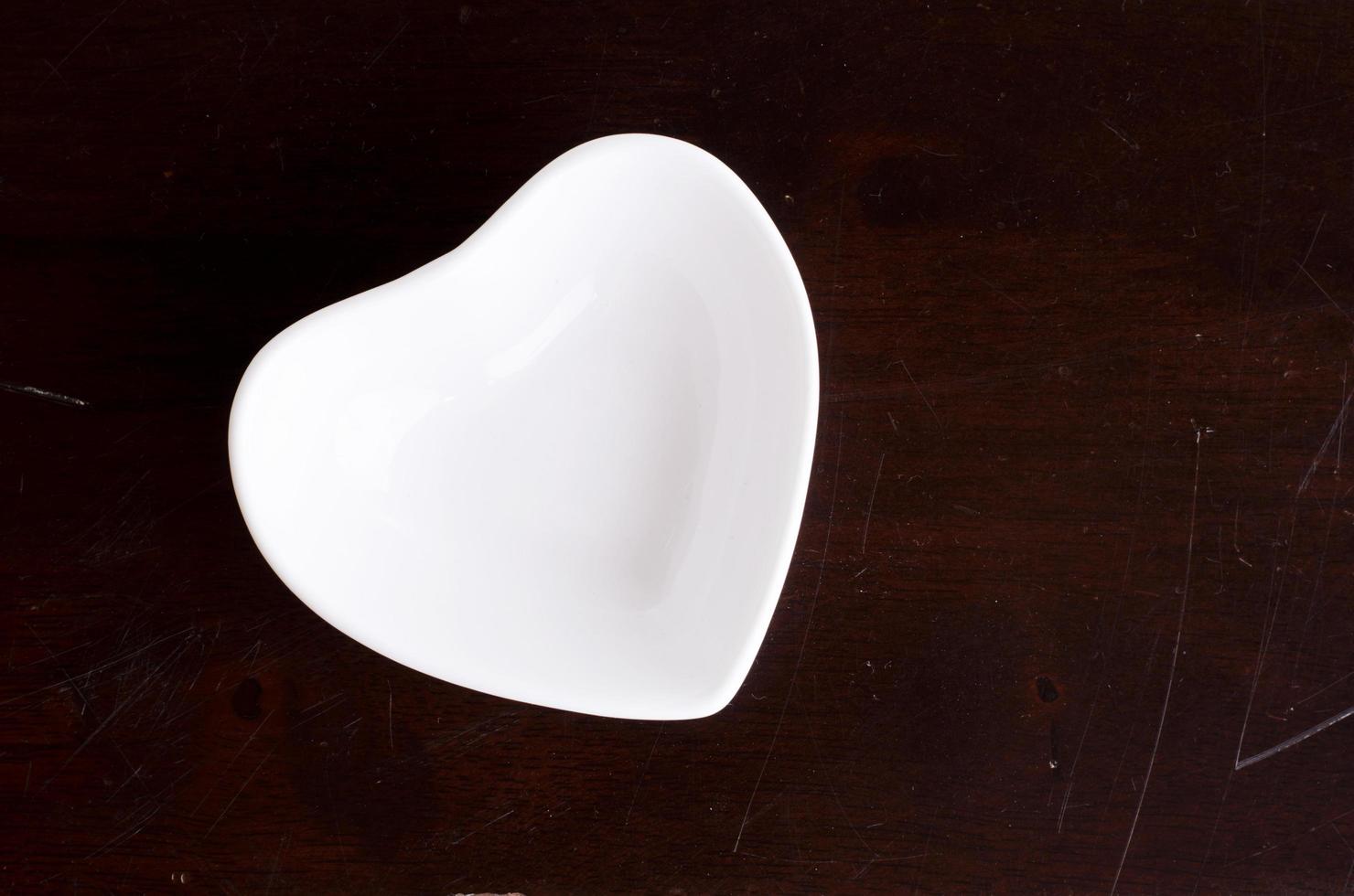 Tasse en forme de coeur vide sur fond de table en bois photo
