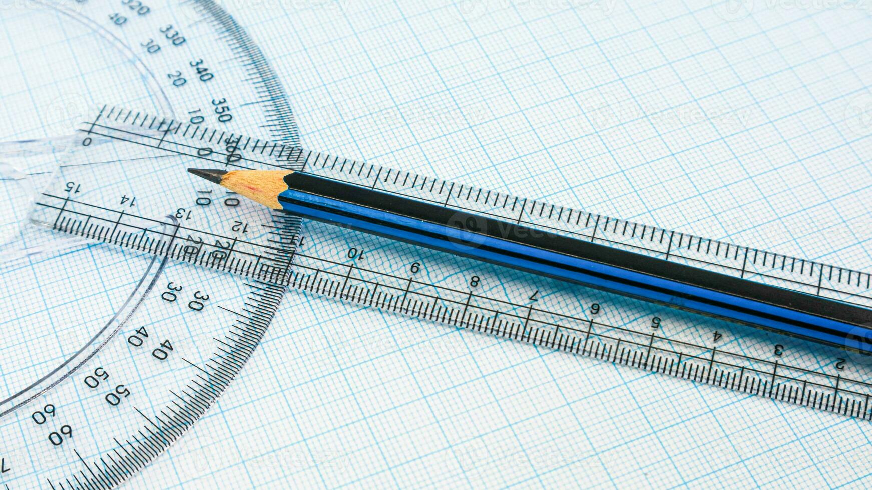 sur bleu graphique papier sont boussoles, rapporteur, règle, et une crayon photo