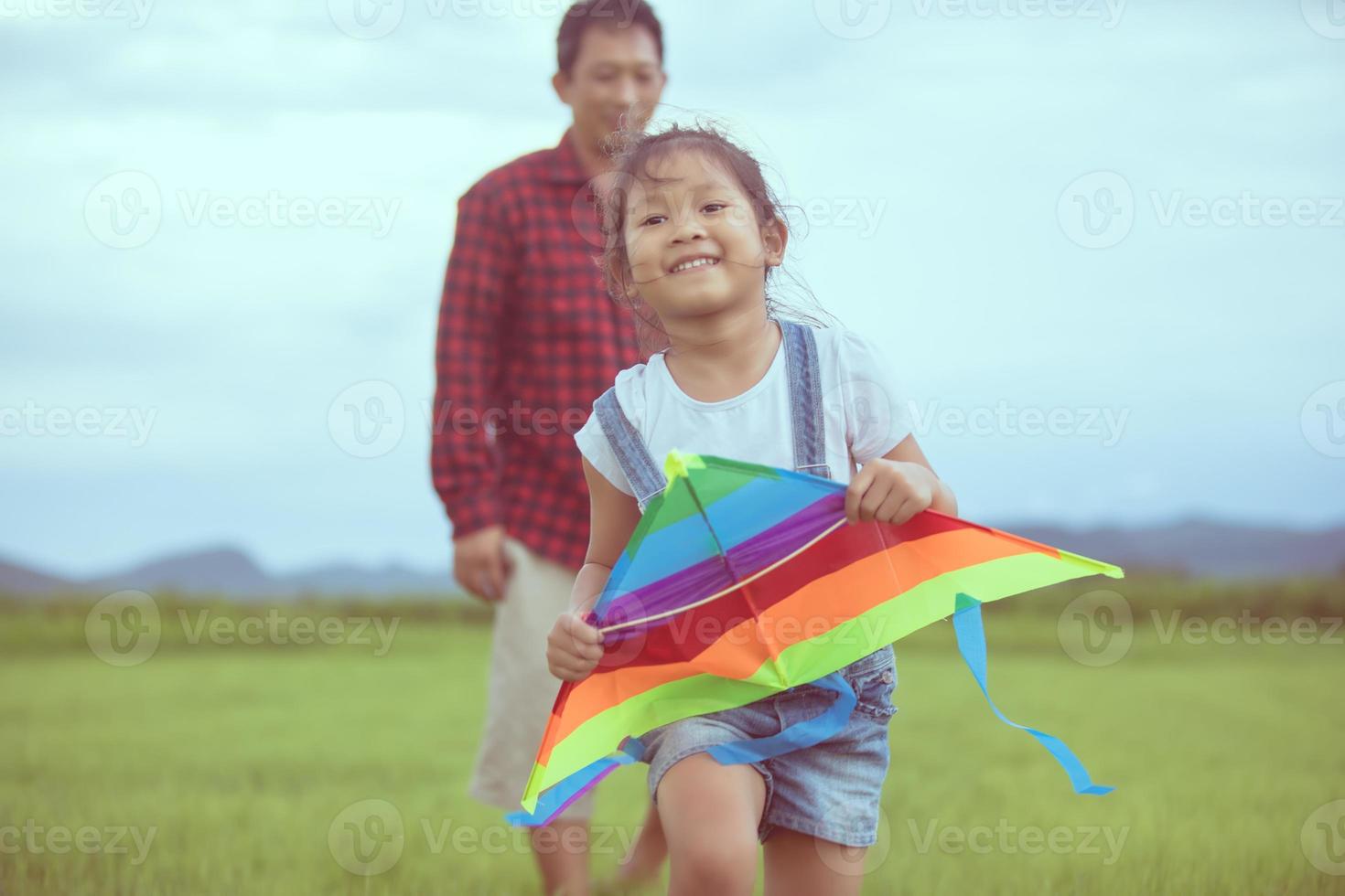 enfant et père jouant avec un cerf-volant dans le parc photo