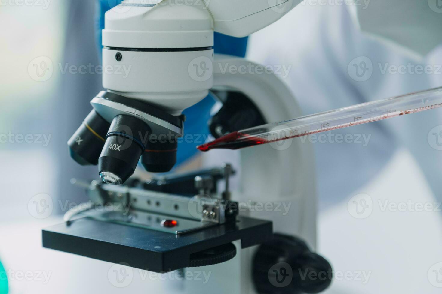 médical ou scientifique chercheur recherche et expérimenter multicolore solution, Fiole et microscope dans le laboratoire ou dans le laboratoire par portant bleu gants et blanc Vêtements complètement. photo