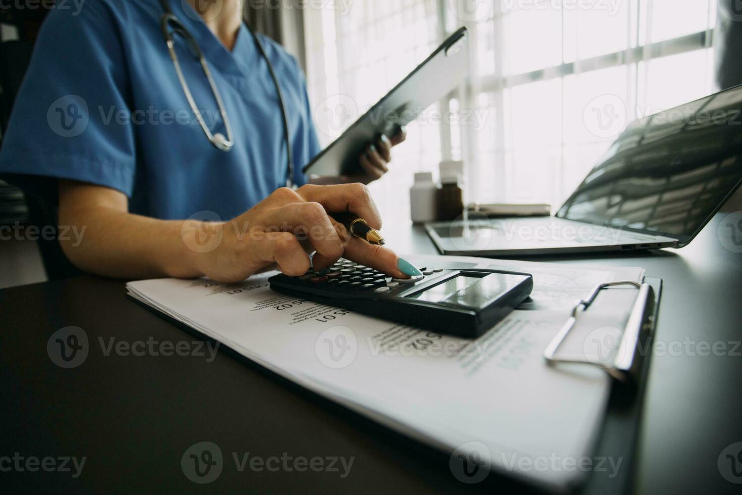 médecin main tenant un stylo écrivant la liste des antécédents du patient sur le presse-papiers sur les médicaments et le traitement. photo