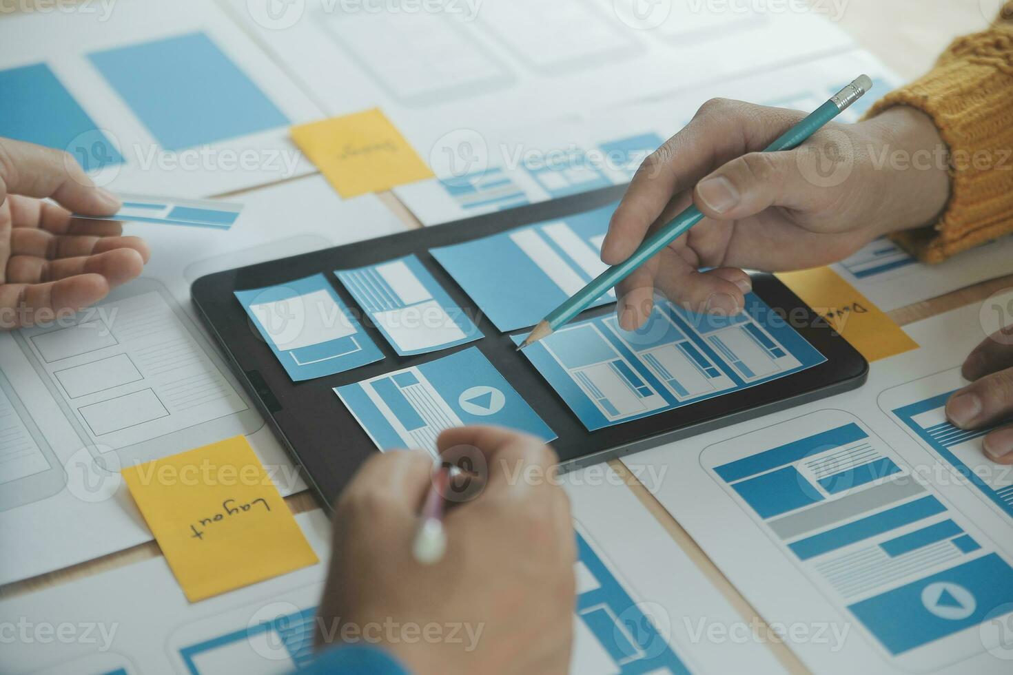 gros plan sur le développeur ux et le concepteur d'interface utilisateur remue-méninges sur la conception filaire de l'interface de l'application mobile sur la table avec le client breif et le code couleur au bureau moderne. agence de développement numérique créative photo