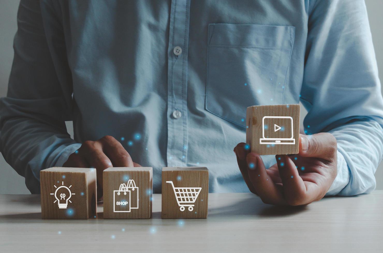 shopping concept d'entreprise en ligne. main de l'homme tenant un cube en bois avec une icône pour faire du shopping. marketing des affaires en ligne. photo