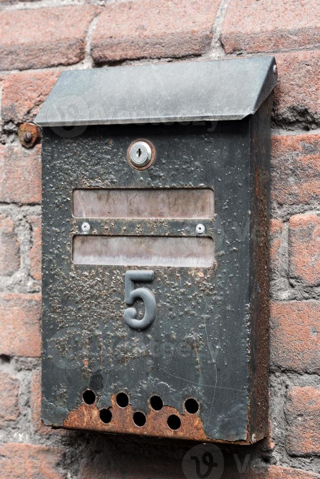 Ancienne boîte aux lettres rouillée avec numéro cinq photo