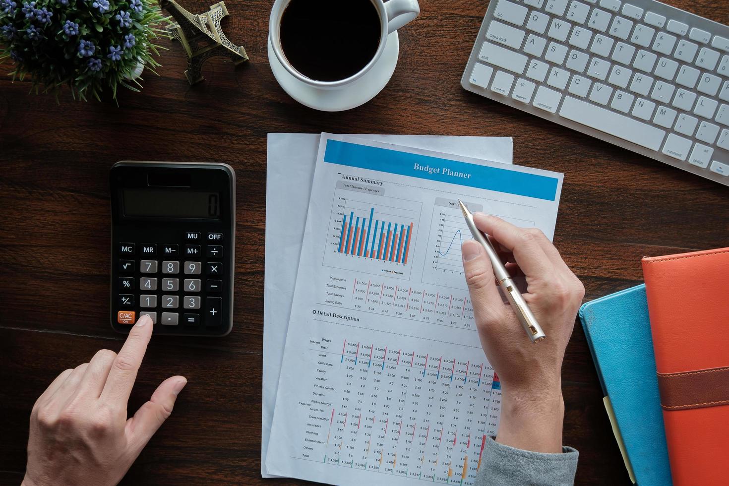 concept de comptabilité d'entreprise, homme d'affaires à l'aide d'un stylo pointant avec un graphique de planificateur de budget de données et une calculatrice pour calculer le papier de plan de financement au bureau. photo