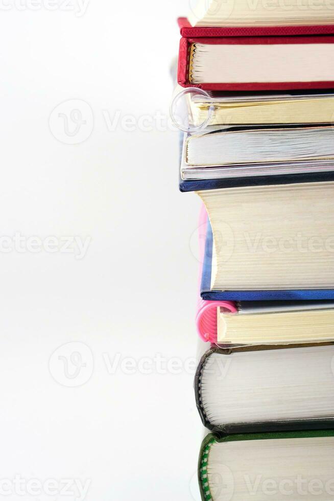 verticale image de le épines de livres sont arrangé sur une blanc Contexte. connaissance, apprentissage et éducation concept. photo