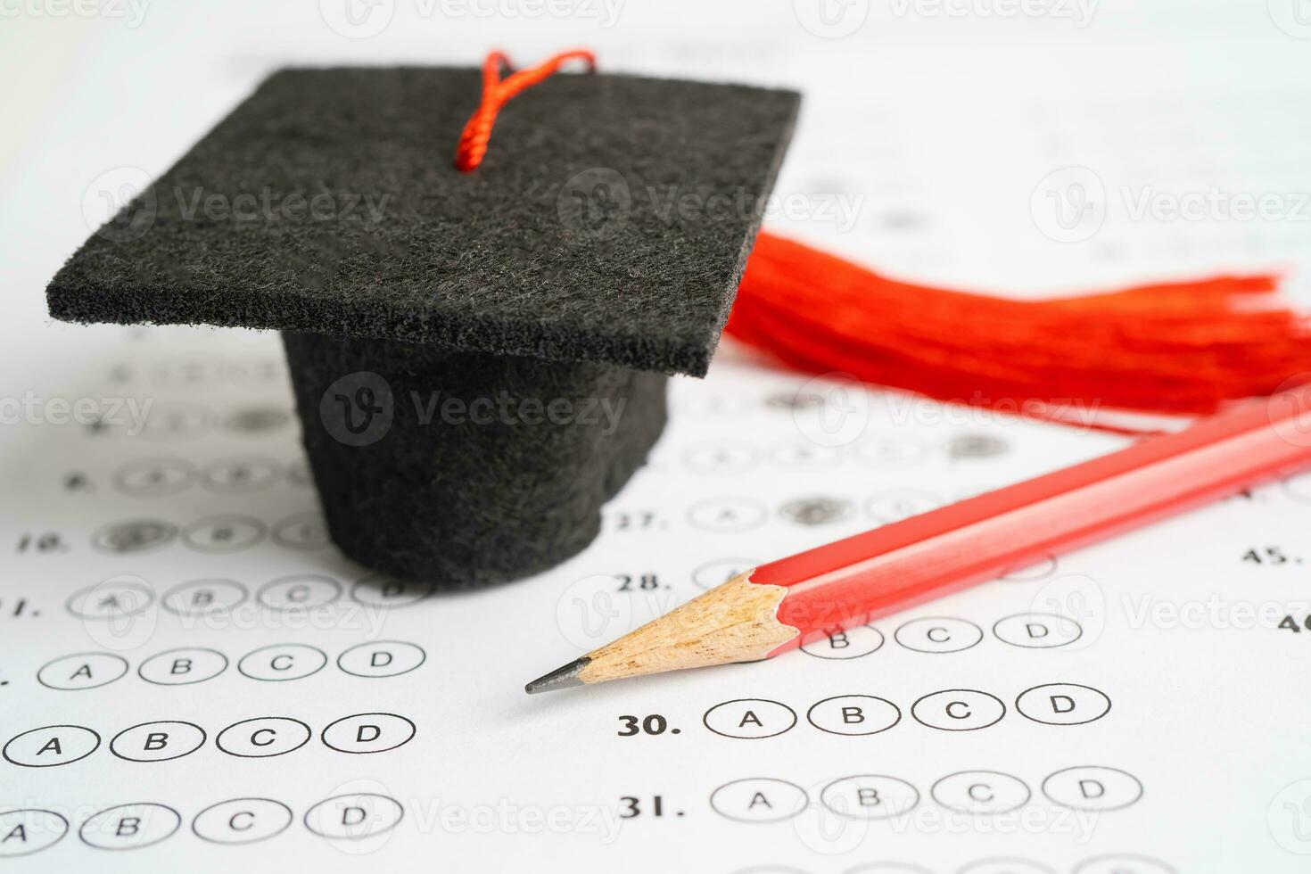 chapeau d'écart de graduation et crayon sur fond de feuille de réponses, étude de l'éducation testant l'apprentissage enseigner le concept. photo