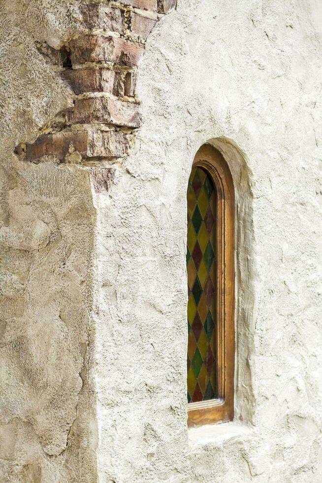 architectural éléments de le mur, les fenêtres avec coloré coloré verre. un vieux mur avec fissures. photo