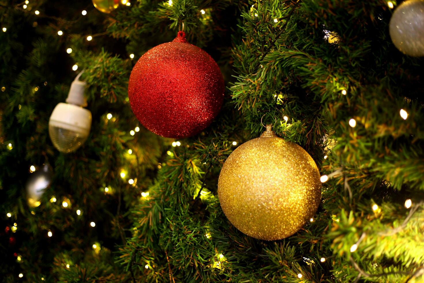 proche en haut décoration Balle et lumière ampoule sur Noël arbre à nuit photo