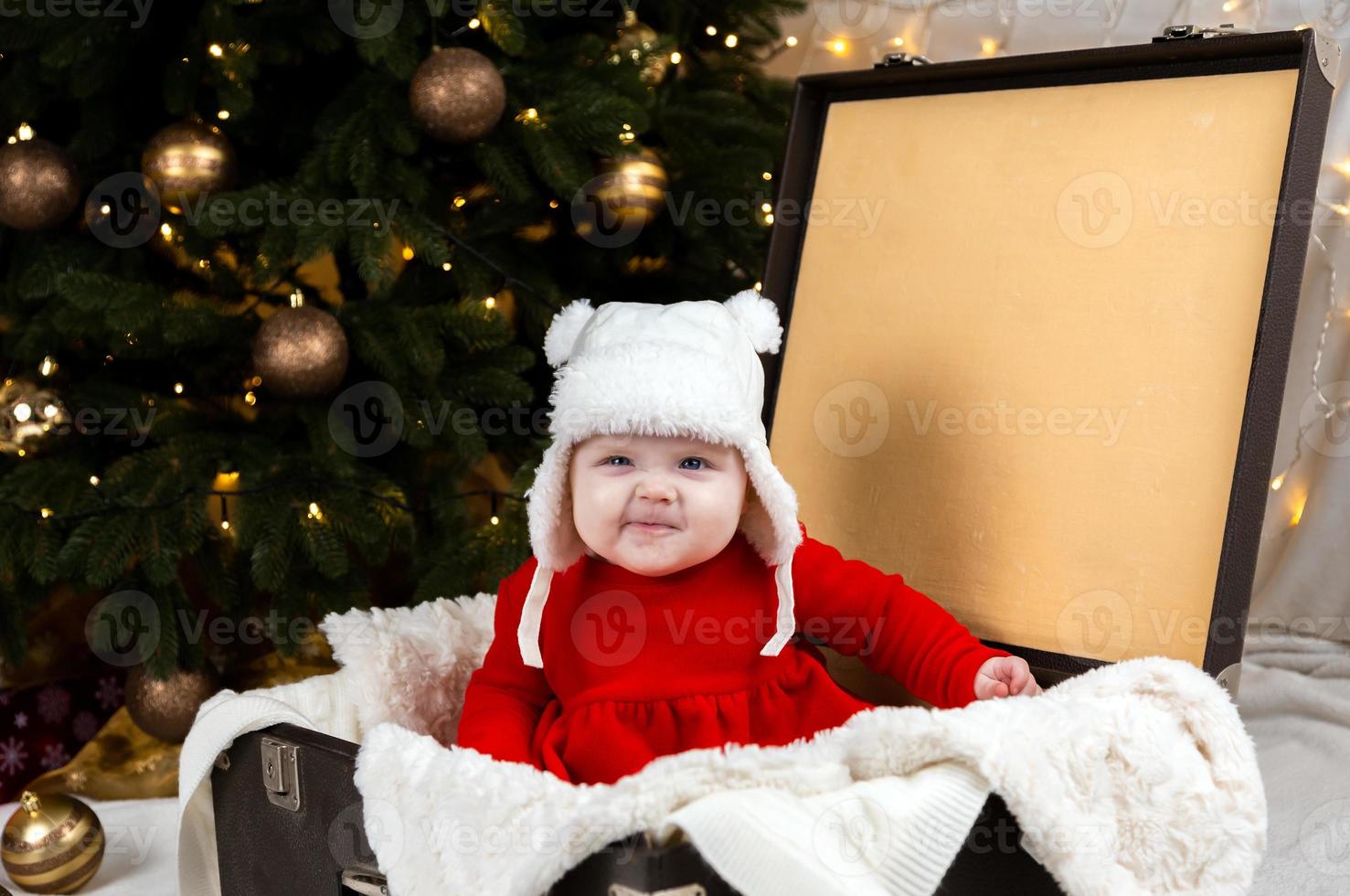 le bébé grimace assis dans une vieille valise photo