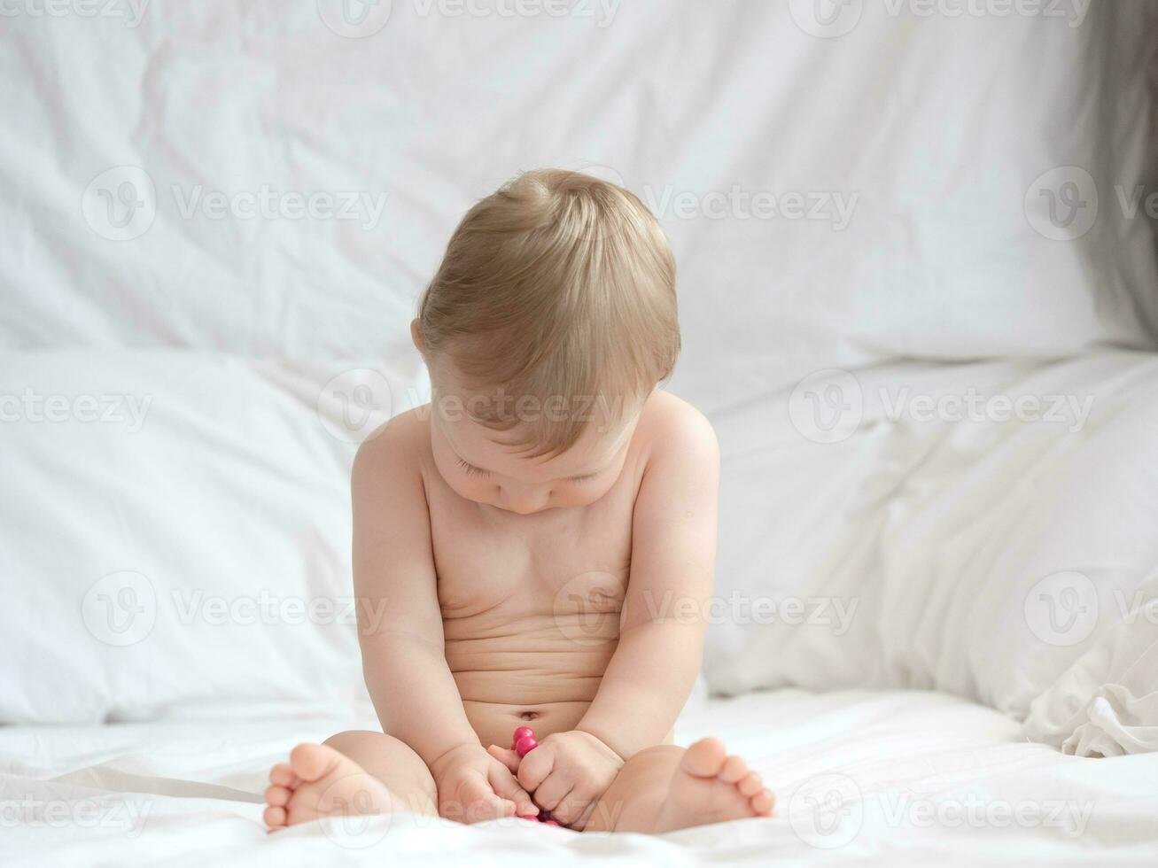 mignonne bébé séance et en train de dormir sur le lit photo