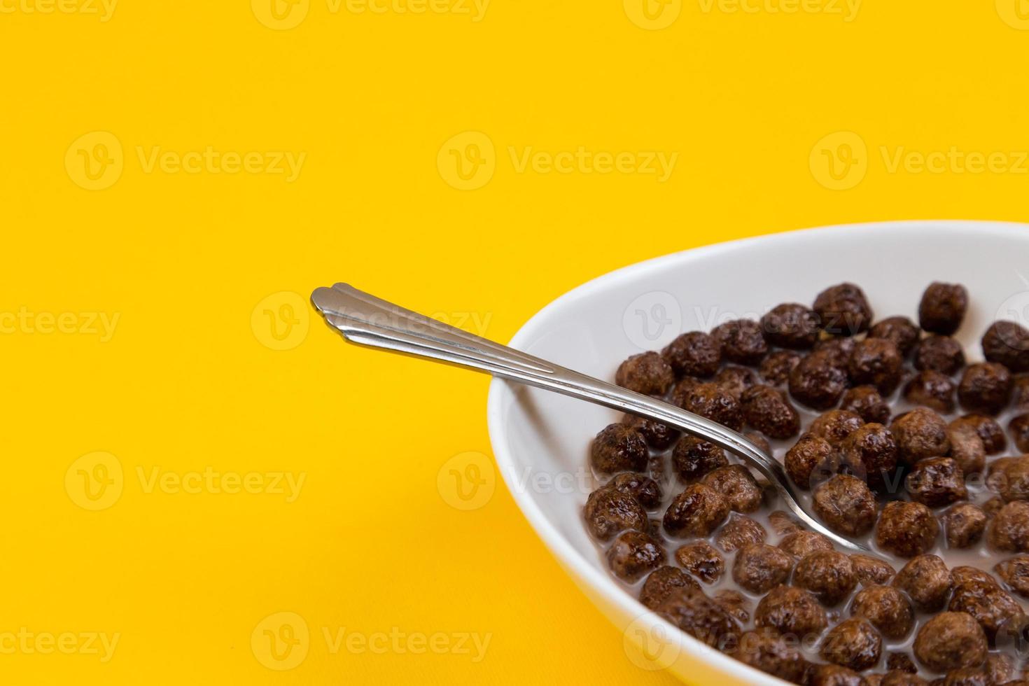 cuillère dans un bol blanc avec des céréales de maïs au chocolat photo