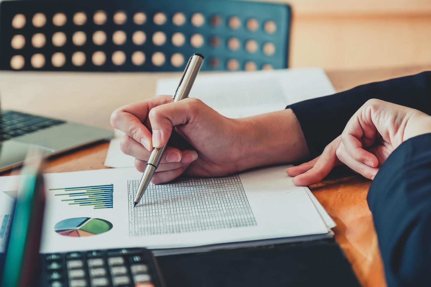 Les femmes d'affaires analysent et vérifient les documents à l'aide d'un ordinateur portable et d'une calculatrice pour calculer les documents budgétaires aux directeurs photo