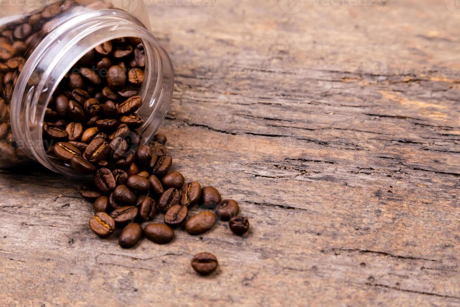 grains de café aromatiques tombés d'un bocal en verre photo