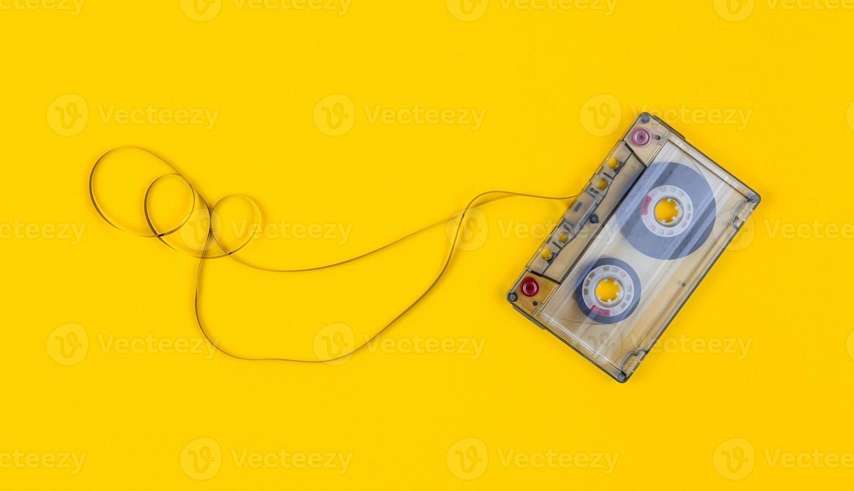 Vue de dessus de la cassette audio avec du ruban emmêlé sur fond jaune vif avec copie espace photo