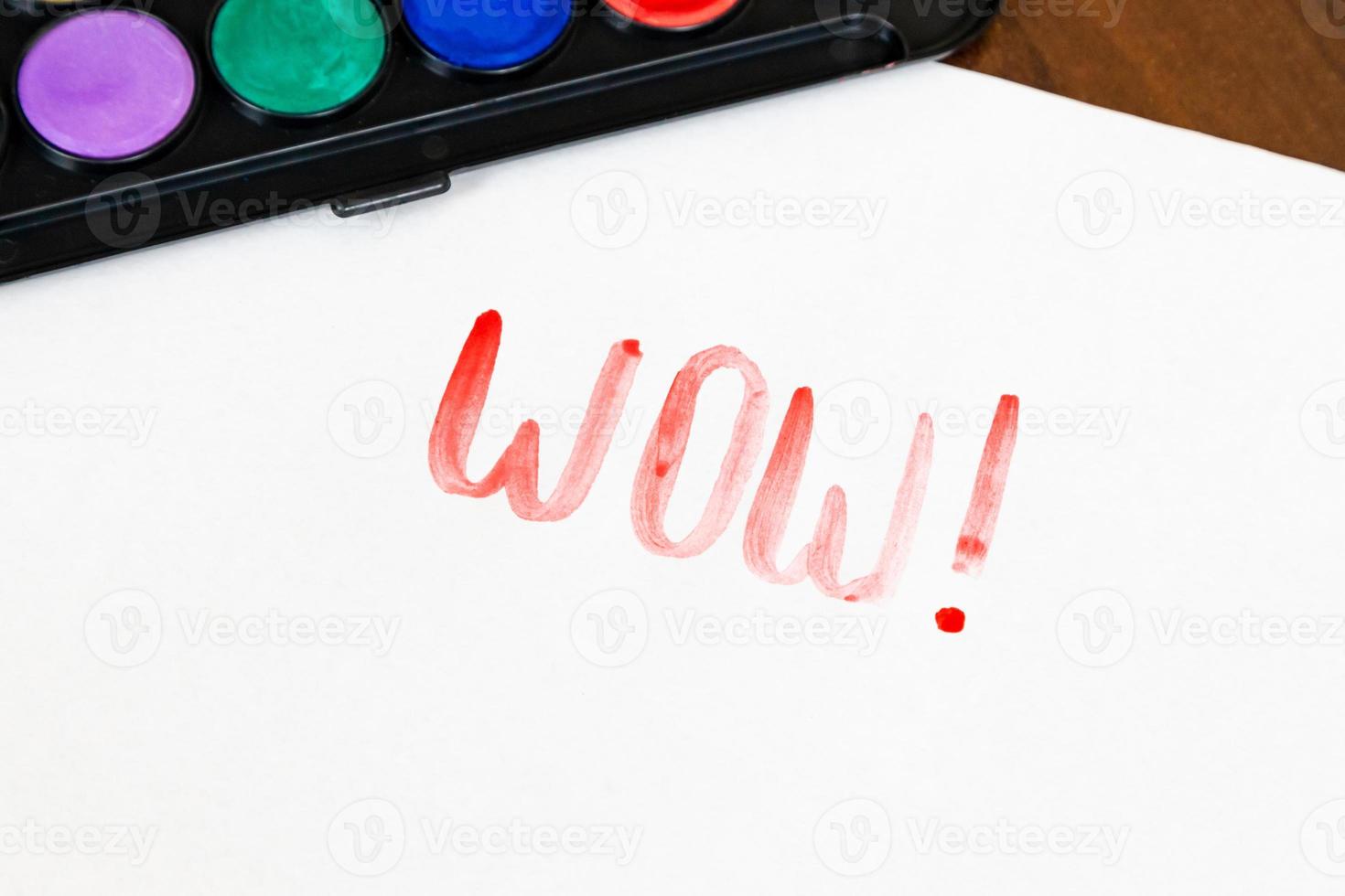 Texte wow manuscrit avec pinceau et peintures à l'aquarelle sur fond blanc photo