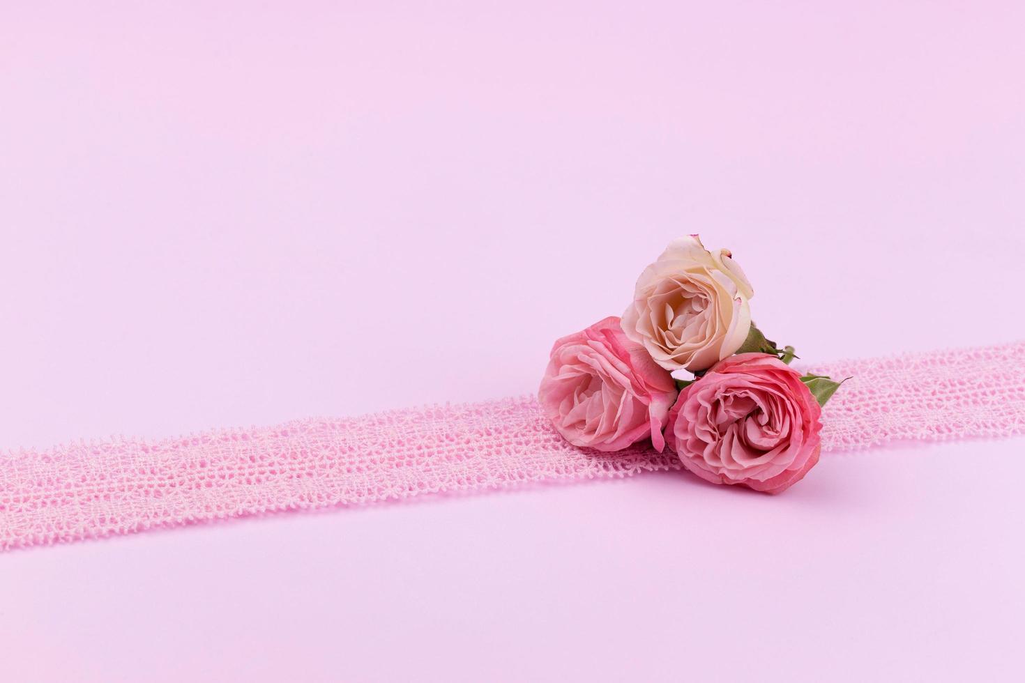 trois roses délicates sur un beau fond rose avec un espace pour le texte photo