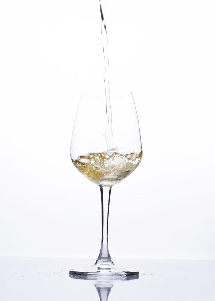 Verser la bière dans un verre à vin isolé sur fond blanc photo