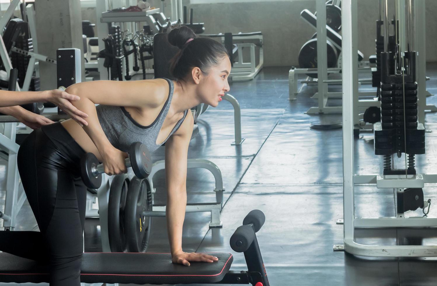 belle femme asiatique exerce dans une salle de sport photo