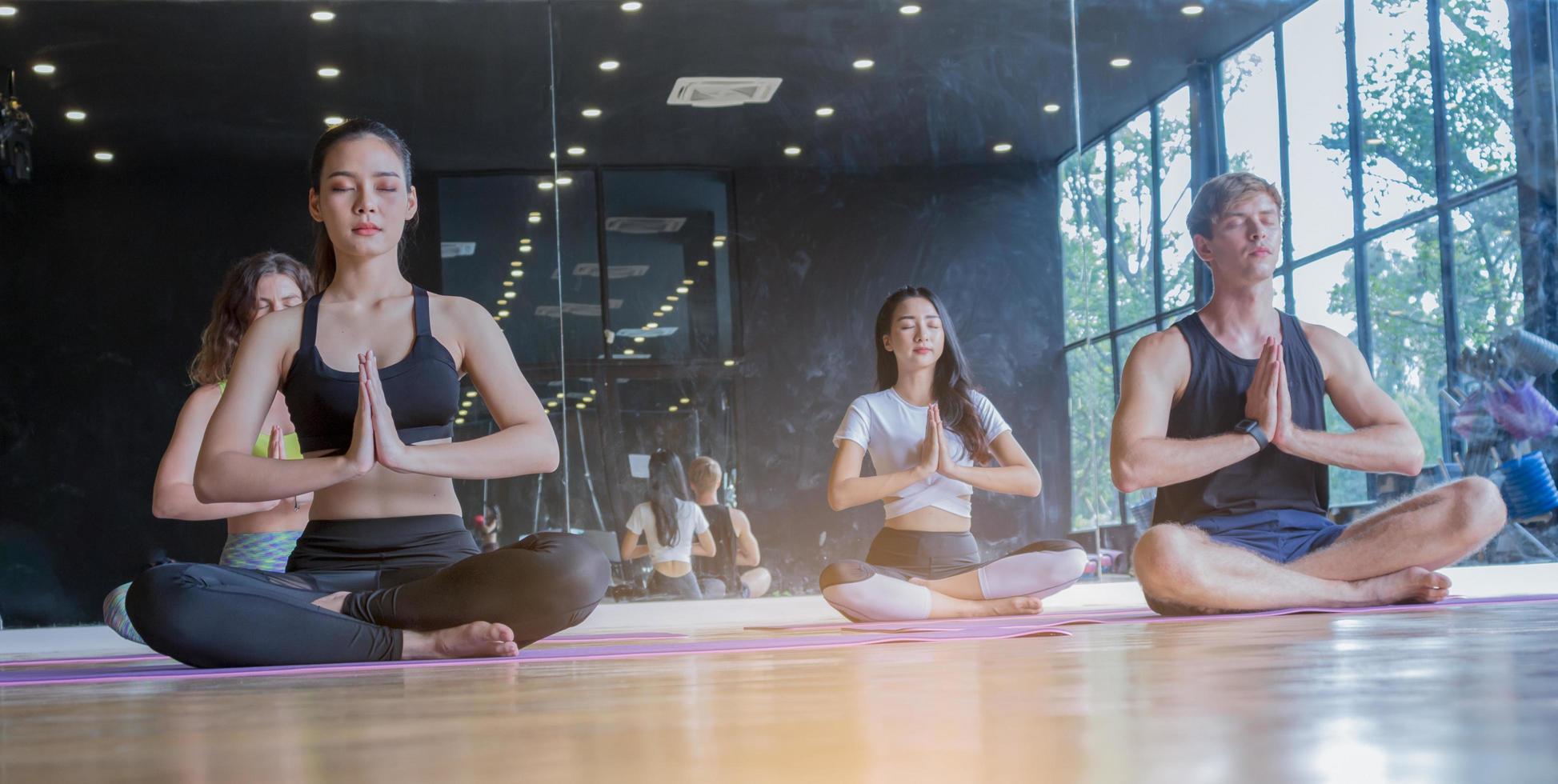 groupe exerçant le yoga dans la salle de gym en étirant, concept d'exercice sain photo