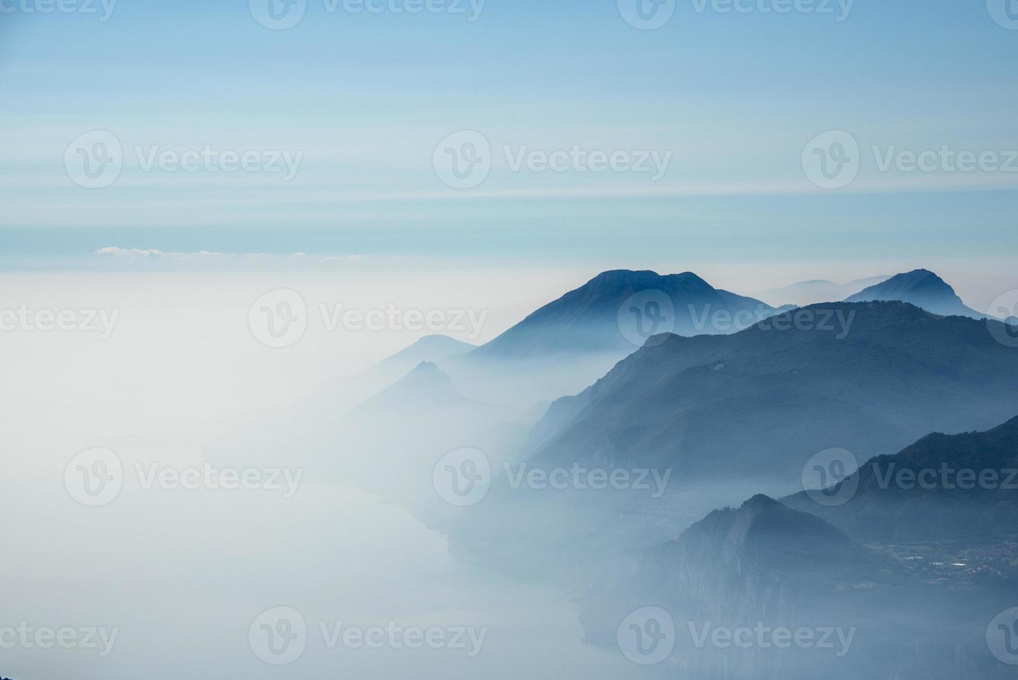 ciel bleu et brouillard dans les montagnes autour du lac de garde photo