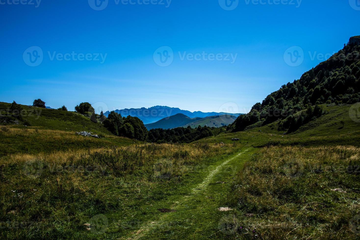 Chemin parmi les pâturages sur le monte altissimo près du lac de garde, trento, italie photo