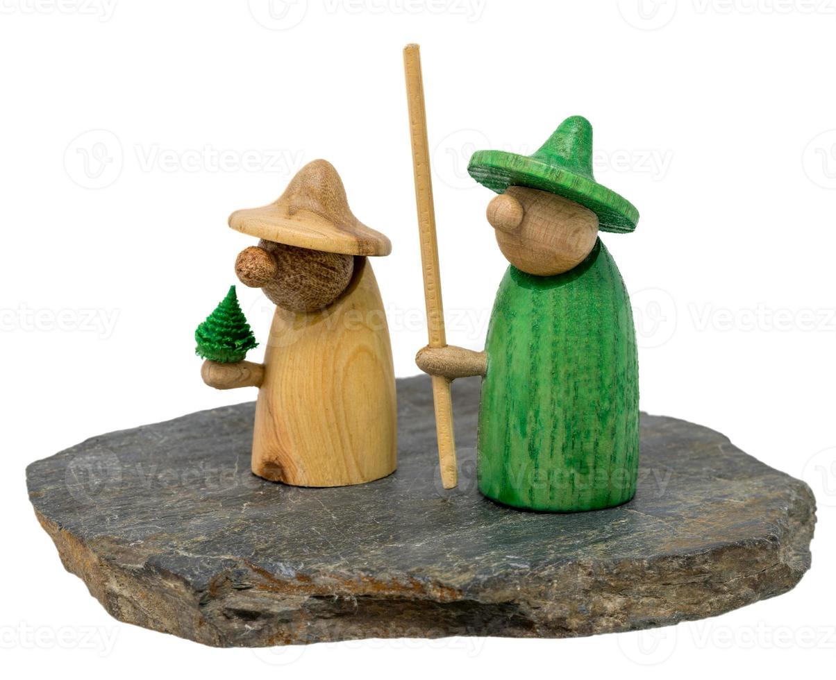 Deux figurines de Noël en bois se tiennent sur une planche de bois sombre photo