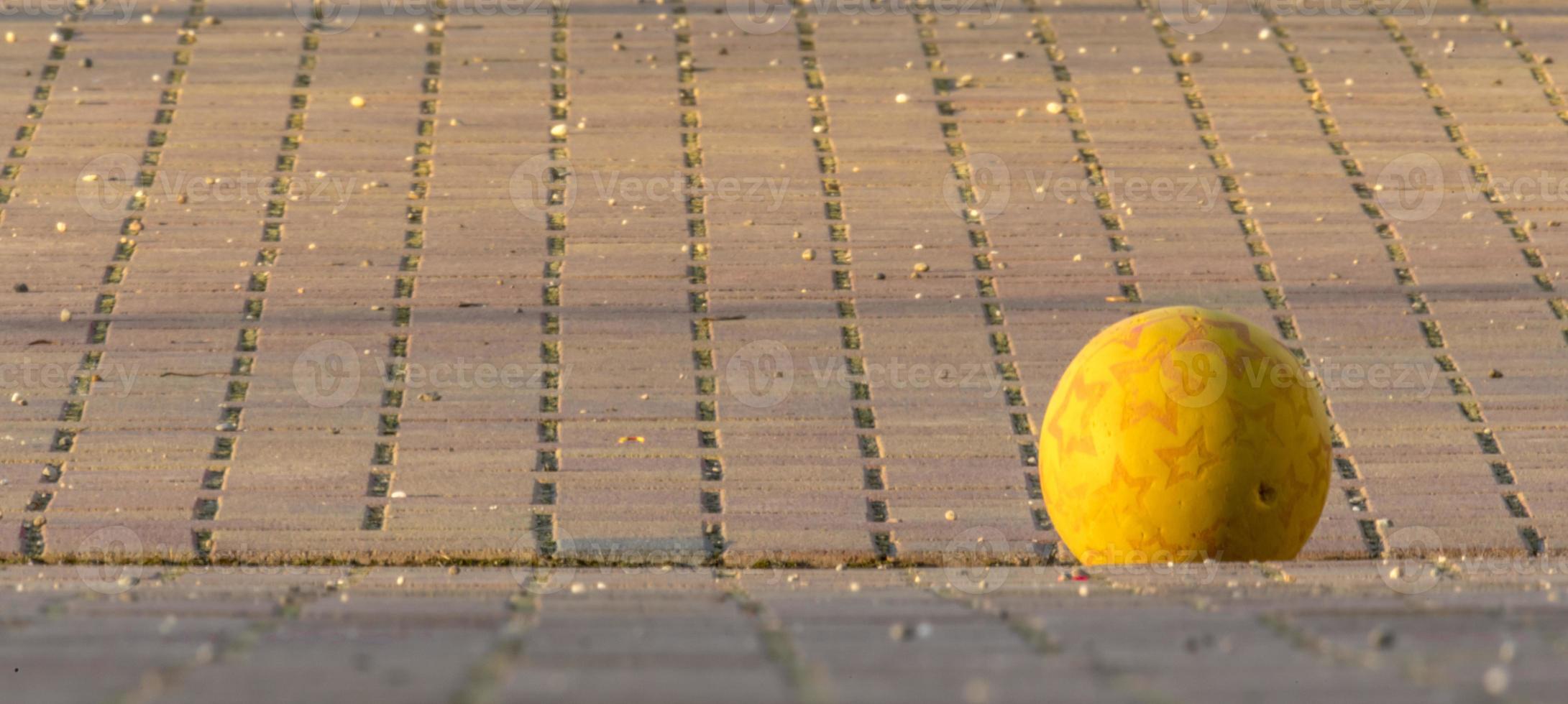 La balle jaune des enfants se trouve sur un endroit pavé photo